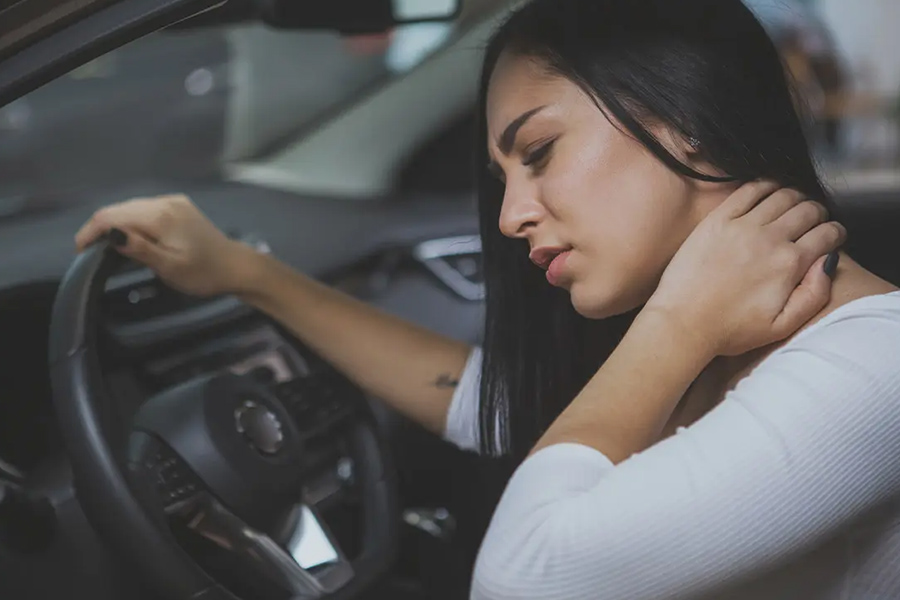 Personal Injury Protection PIP Insurance - Young Woman Rubbing Her Neck and Feeling Sore After Whiplash in a Car Crash